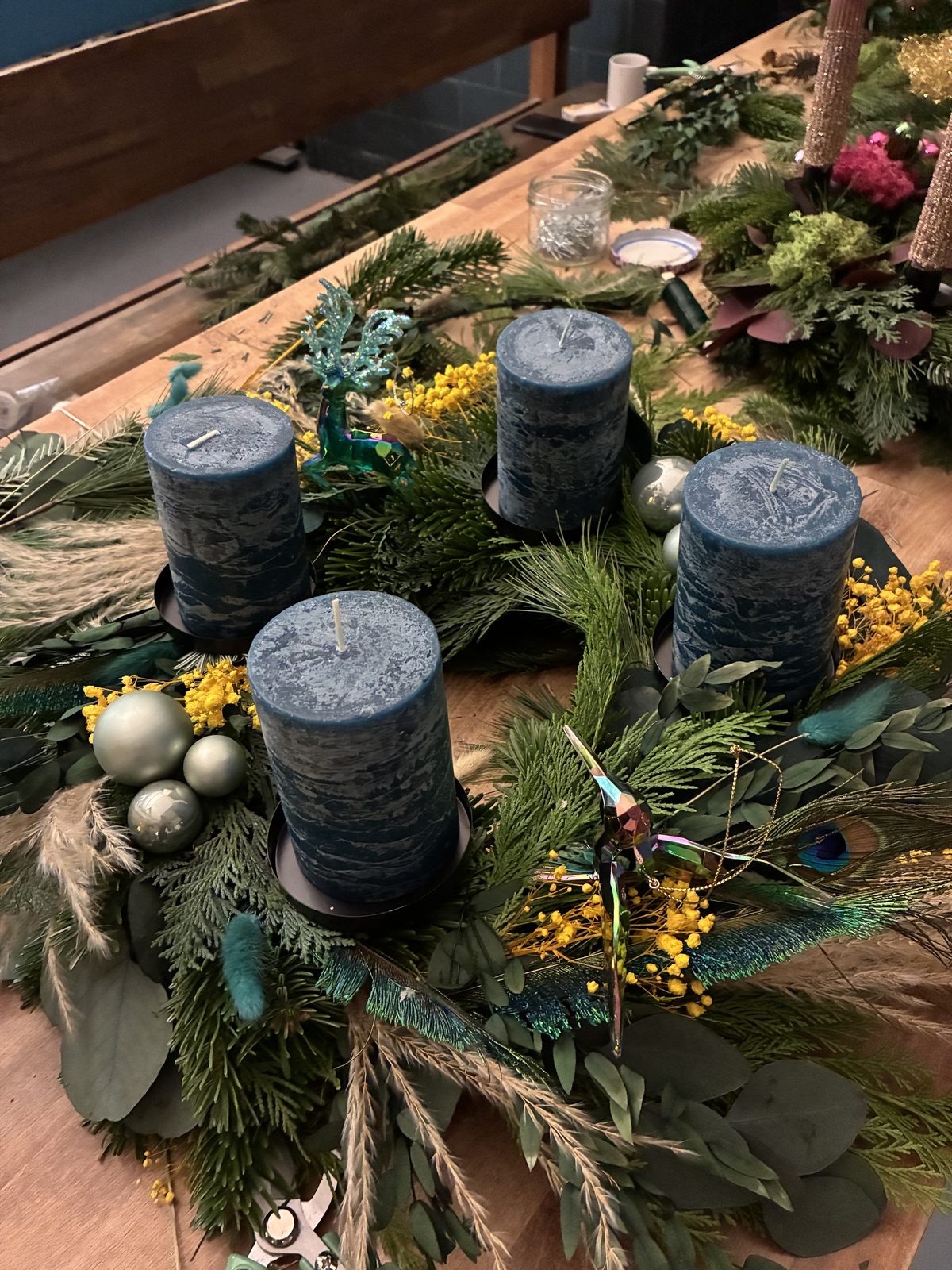 Adventskranz mit dunklen Kerzen und Mimosen